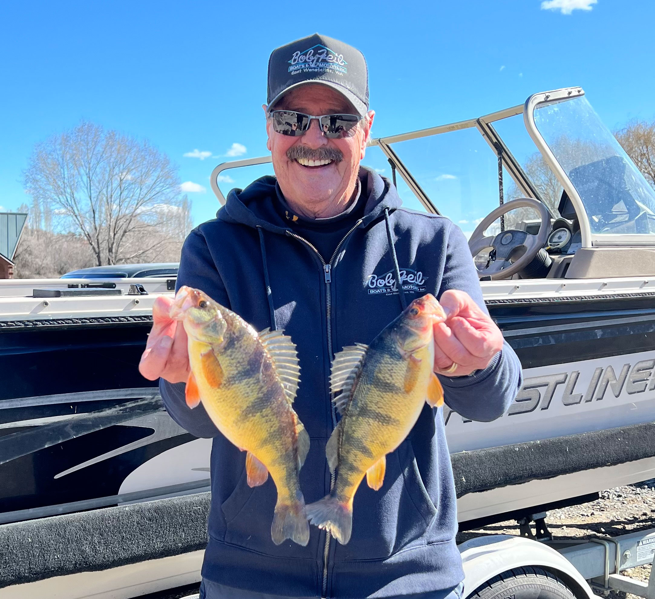 Dave Graybill holding two jumbo perch caught at Moses Lake, showcasing the early spring bite