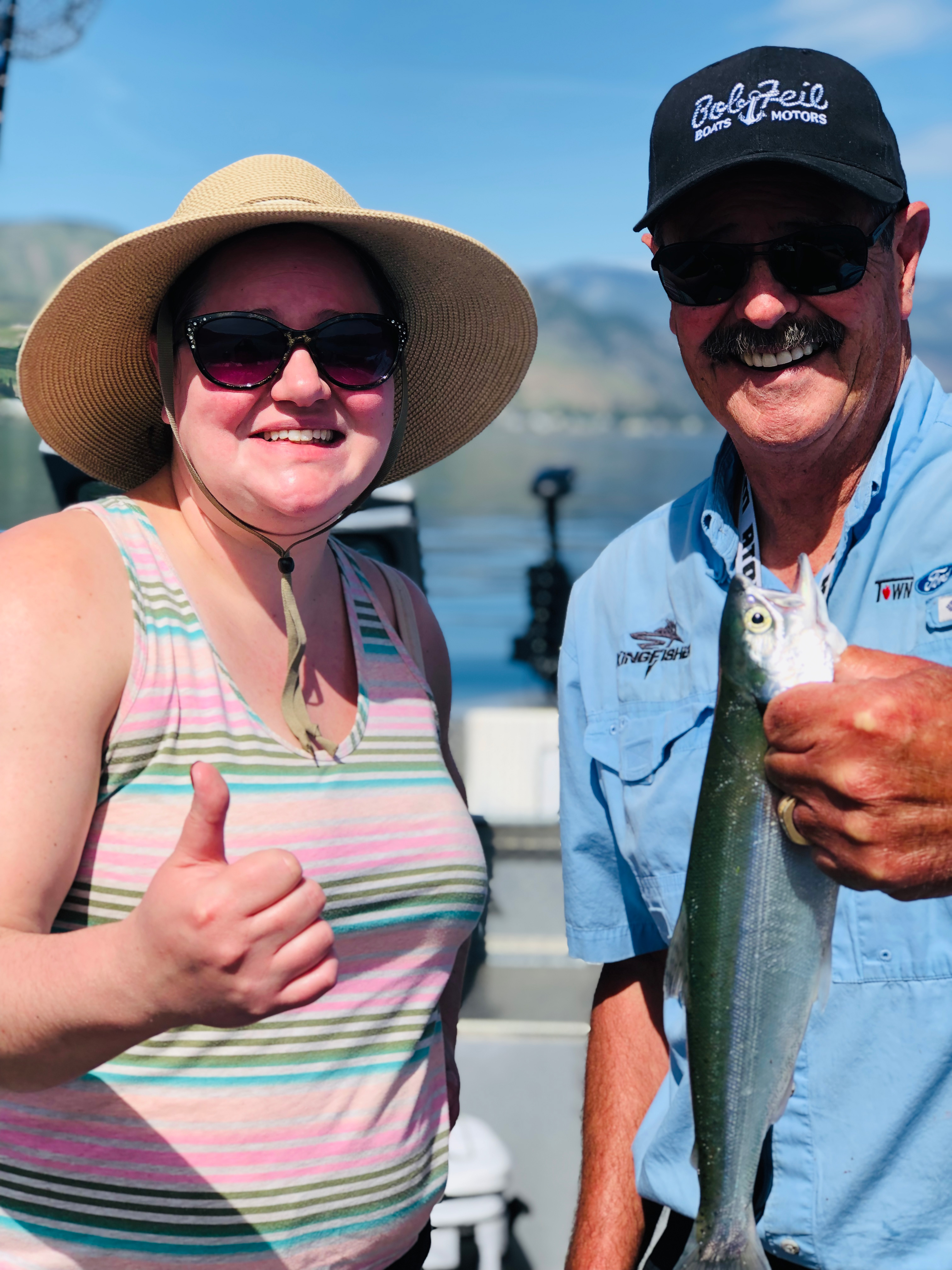 Dave Graybill and his daughter fishing for kokanee on Lake Chelan, smiling and enjoying the day on the boat.